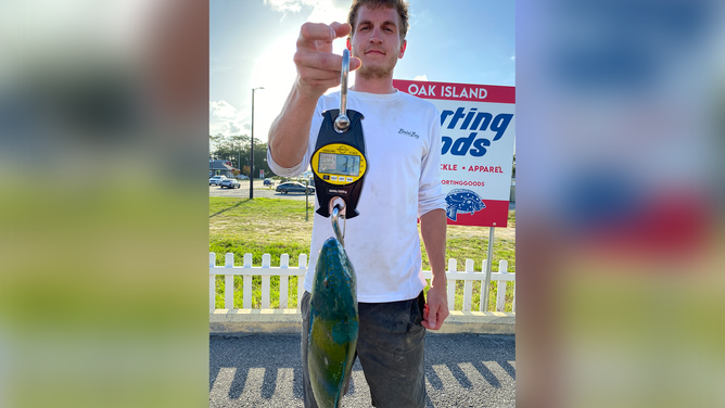 Connor Stone, 30, holding a colorful puddingwife fish.