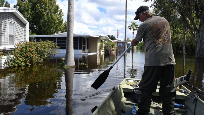 ST CLOUD, FLORIDA, UNITED STATES - 2022/10/04: Kit Brown paddles his boat in a flooded street near his home in the Jade Isle Mobile Home Park in St. Cloud. Residents of the community were issued a voluntary evacuation order due to rising water levels in the aftermath of Hurricane Ian. (Photo by Paul Hennessy/SOPA Images/LightRocket via Getty Images)