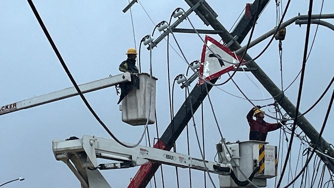 Utility workers try to repair power lines downed by the high winds from Typhoon Koinu in Taiwan's southern Pingtung County on October 5, 2023.