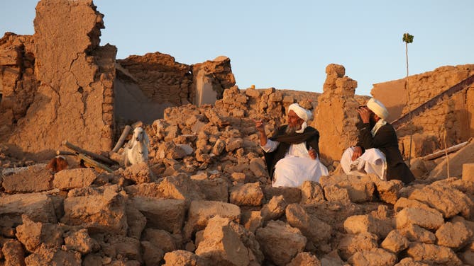 Afghan residents sit at a damaged house after earthquake in Sarbuland village of Zendeh Jan, district of Herat province, on October 7,2023.