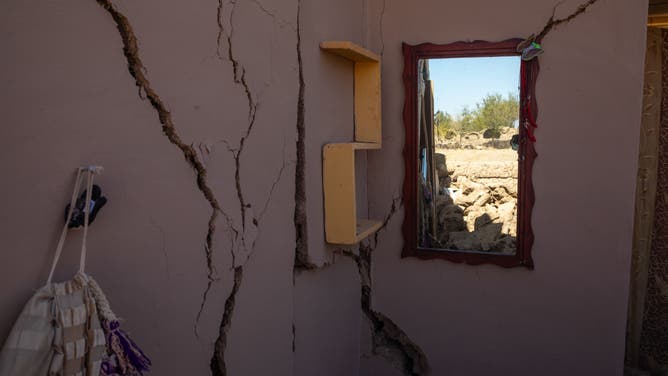 10/08/2023 Herat, Afghanistan. Cracked walls and rubble are seen in a house in Herat after a massive 6.3 magnitude earthquake struck the city, resulting in thousands of injuries and fatalities. Afghan mourners are seen covering a grave with soil following the funeral prayers for the victims of the earthquakes in Kashkak village, Zendeh Jan district of Herat province on October 8, 2023. The death toll from a series of earthquakes in western Afghanistan drastically increased on October 8, with the number surpassing 2,000, and nearly 10,000 people reported as injured. Rescue workers tirelessly searched through destroyed villages, hoping to find any signs of life. According to officials, more than 1,300 homes were demolished when a magnitude 6.3 earthquake, followed by eight strong aftershocks, struck remote areas located 30 kilometers (19 miles) northwest of the provincial capital of Herat. (Photo by Muhammad Balabuluki / Middle East Images / Middle East Images via AFP) (Photo by MUHAMMAD BALABULUKI/Middle East Images/AFP via Getty Images)