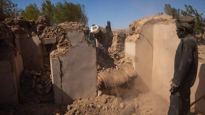 10/08/2023 Herat, Afghanistan. Afghan men comb through the rubble to collect belongings and recover bodies in the aftermath of a devastating 6.3 magnitude earthquake in Herat, resulting in the loss of 2,000 lives and leaving 10,000 injured. Afghan mourners are seen covering a grave with soil following the funeral prayers for the victims of the earthquakes in Kashkak village, Zendeh Jan district of Herat province on October 8, 2023. The death toll from a series of earthquakes in western Afghanistan drastically increased on October 8, with the number surpassing 2,000, and nearly 10,000 people reported as injured. Rescue workers tirelessly searched through destroyed villages, hoping to find any signs of life. According to officials, more than 1,300 homes were demolished when a magnitude 6.3 earthquake, followed by eight strong aftershocks, struck remote areas located 30 kilometers (19 miles) northwest of the provincial capital of Herat. (Photo by Muhammad Balabuluki / Middle East Images / Middle East Images via AFP) (Photo by MUHAMMAD BALABULUKI/Middle East Images/AFP via Getty Images)