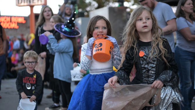 Joey Salaz, 6, front left, and Emma Martin, 6, right, are waiting during the sixth annual Broadway Halloween Parade hosted by the Broadway Merchants Association and Lucky District 7 Council office took place in Denver, Colorado on Saturday, October 21, 2023.