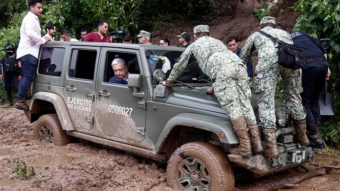 Mexican President Andres Manuel Lopez Obrador looks out of the window as the vehicle transporting his is stuck in mud during a visit to the Kilometro 42 community, near Acapulco, Guerrero State, Mexico, after the passage of Hurricane Otis, on October 25, 2023. 