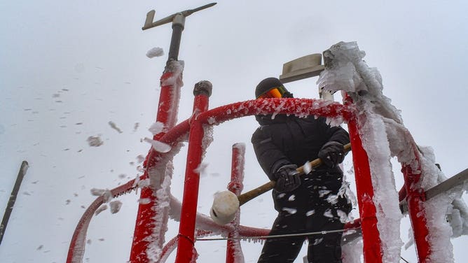 A weather observer knocks off rime ice at the Mount Washington Observatory in New Hampshire.