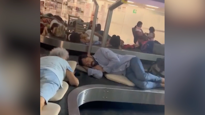 Air travelers sleep on luggage carousel in Acapulco.