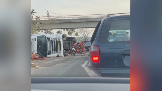 Tipped-over bus and semi-truck in Acapulco.