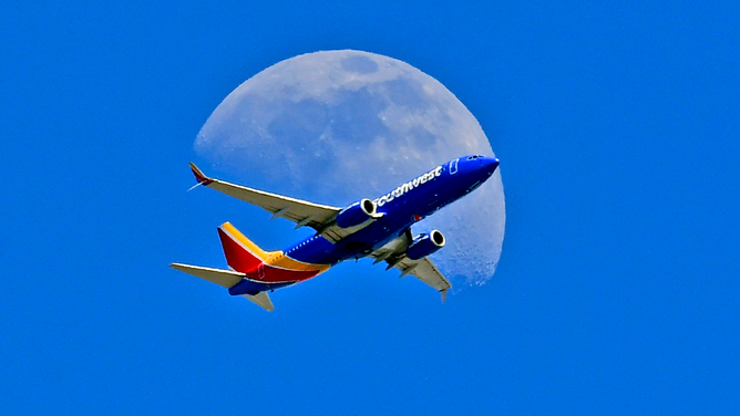FILE - A Southwest Airlines Boeing 737 plane files in front of the moon on July 07, 2022 in Whittier, California.