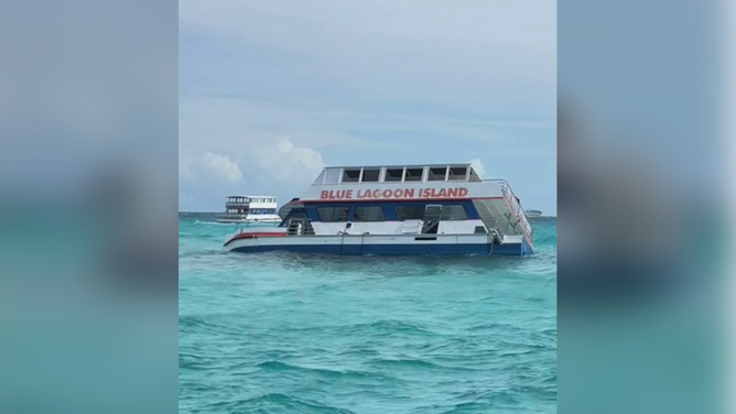 An image showing a boat listing to one side after taking on water while heading to the popular tourist destination Blue Lagoon Island in the Bahamas.