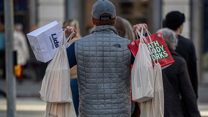 A shopper carries bags in San Francisco, California, US, on Wednesday, Dec. 21, 2022.