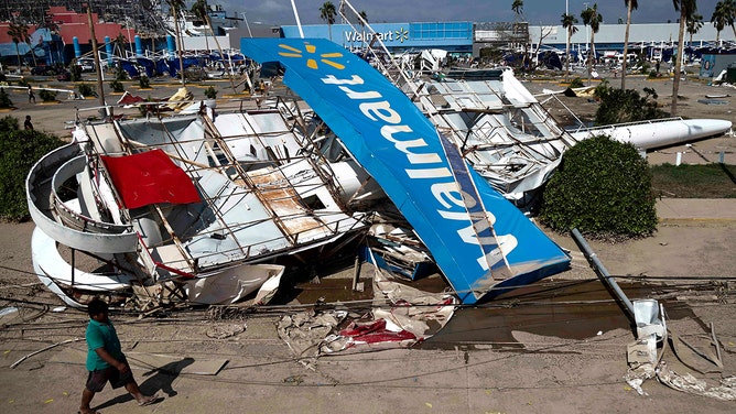 Residents walk past debris in the aftermath of hurricane Otis in Acapulco, Guerrero State, Mexico, on October 27, 2023.