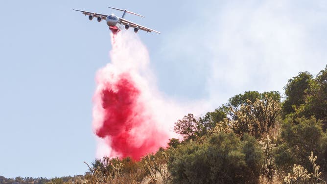 A plane drops fire retardant during the Highland Fire in Aguanga, California, US, on Tuesday, Oct. 31, 2023.