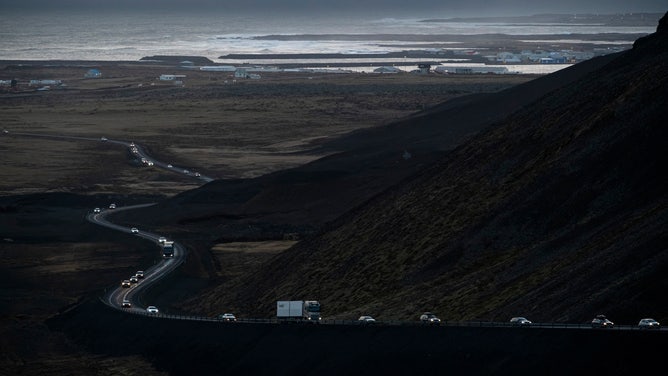 This photo taken on November 13, 2023 shows vehicles leaving the town of Grindavik, southwestern Iceland, during evacuation following earthquakes. The southwestern town of Grindavik -- home to around 4,000 people -- was evacuated in the early hours of November 11 after magma shifting under the Earth's crust caused hundreds of earthquakes in what experts warned could be a precursor to a volcanic eruption. The seismic activity damaged roads and buildings in the town situated 40 kilometres (25 miles) southwest of the capital Reykjavik, an AFP journalist saw. (Photo by Kjartan TORBJOERNSSON / AFP) / Iceland OUT (Photo by KJARTAN TORBJOERNSSON/AFP via Getty Images)