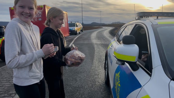 GRINDAVIK, ICELAND - NOVEMBER 12: Children bring food to police and emergency workers outside Grindavik on November 12, 2023 in Grindavik, Iceland. Iceland has declared a state of emergency after a series of earthquakes with authorities ordering thousands of people to leave the southwestern town of Grindavík as a precaution.The Icelandic Meteorological Office (IMO) has said there was a considerable risk of a volcanic eruption. (Photo by Micah Garen/Getty Images)