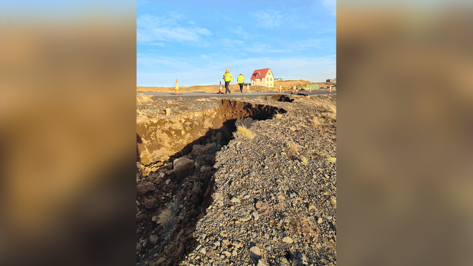 Crews inspect a road after a large crack appeared amid fears that a volcano will erupt there soon.