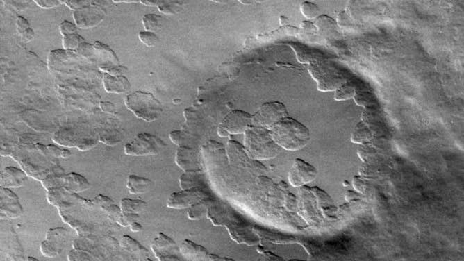 An image captured by Odyssey's camera, Thermal Emission Imaging System, or THEMIS, of smooth material covering the flanks of the volcano Peneus Patera, located south of the Hellas Basin. This image demonstrates the usual top-down angle of the camera.