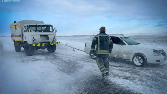 A car being towed in the snow during a winter storm in Ukraine.