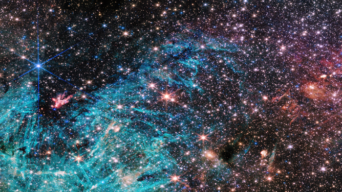 The NIRCam (Near-Infrared Camera) instrument on NASA’s James Webb Space Telescope’s reveals a portion of the Milky Way’s dense core in a new light. An estimated 500,000 stars shine in this image of the Sagittarius C (Sgr C) region, along with some as-yet unidentified features. A large region of ionized hydrogen, shown in cyan, contains intriguing needle-like structures that lack any uniform orientation.