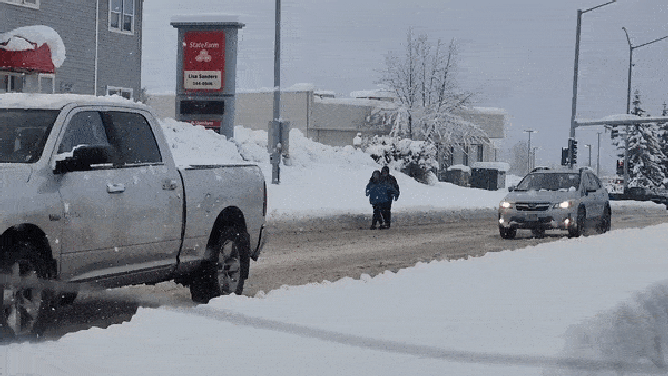 Sidewalks in Anchorage are covered in about 2 feet of snow, forcing pedestrians to walk on the road. Nov. 11, 2023.