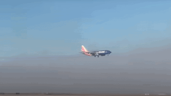 A Southwest Airlines jet flies into dense fog at Denver International Airport.