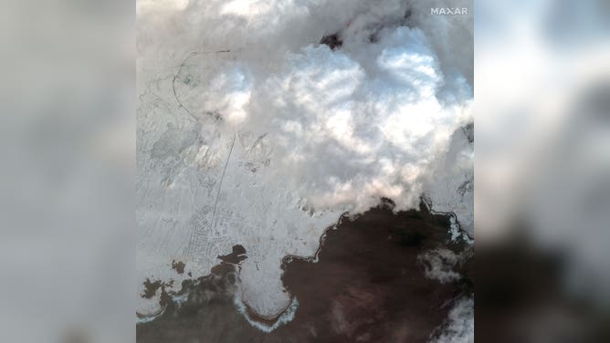 Grindavik, Iceland (bottom-left) is seen near the lava field of an erupting volcano (top-right) on Dec. 19, 2023.