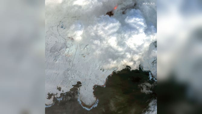 Grindavik, Iceland (bottom-left) is seen near the lava field of an erupting volcano (top-right) on Dec. 19, 2023.