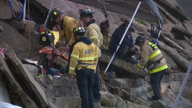 Crews work to rescue a man after he fell into a hole on the side of a cliff in San Diego, California, on Dec. 22, 2023.