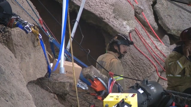 Crews work to rescue a man after he fell into a hole on the side of a cliff in San Diego, California, on Dec. 22, 2023.