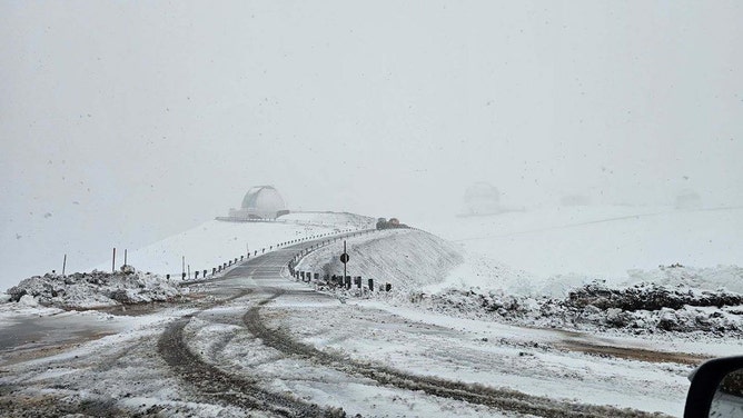 Snow continued to fall Thursday on the summit of Mauna Kea Observatory. The road to the summit is closed until further notice due to icy conditions.