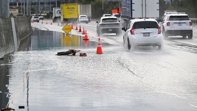 Left lane is closed as cars commute on Highway 101 near the San Francisco International Airport (SFO) as heavy rain hits in South San Francisco, California, United States on December 20, 2023.