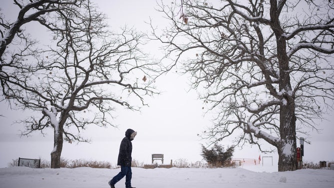 FILE - A silhouetted walker made his way around Lake Harriet in Minneapolis, Minn. as falling snow obscured the horizon late Tuesday afternoon, February 22, 2023. (Photo by Jeff Wheeler/Star Tribune via Getty Images)