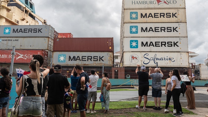 Tourists watch as a container ship navigates through the Miraflores locks of the Panama Canal near Panama City, Panama, on Friday, Nov. 3, 2023.