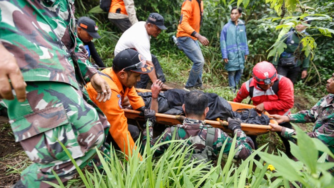 Ratownicy niosą ofiarę erupcji góry Agam na zachodniej Sumatrze 4 grudnia 2023 r.  4 grudnia znaleziono zwłoki 11 alpinistów, a 12 innych uznano za zaginione.  Ci, którzy przeżyli, zostali spaleni z góry pieszo.  (Zdjęcie: FAIRUZ SYAUGI / AFP) (Zdjęcie: FAIRUZ SYAUGI/AFP za pośrednictwem Getty Images)