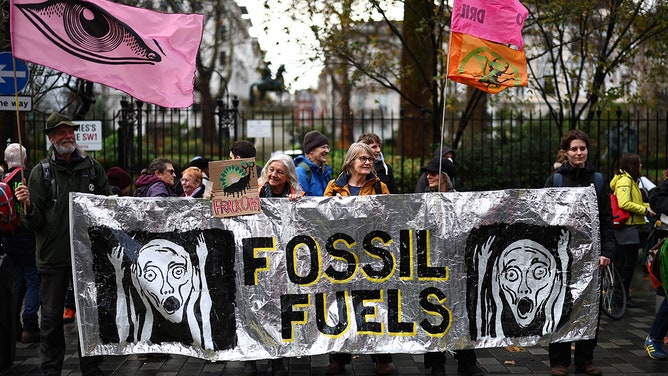 Environmental activists hold up placards during a demonstration outside the headquarters of BP (formerly British Petroleum) in central London on December 9, 2023, gathering in solidarity with people on the frontlines of the climate crisis.