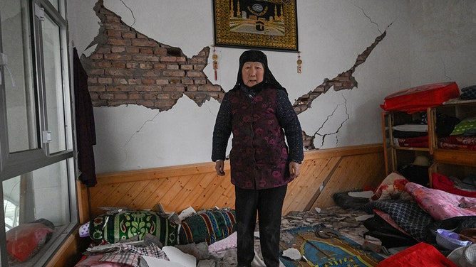 A woman shows the damage to her home after an earthquake in Dahejia, Jishishan County in northwest China's Gansu province on December 19, 2023.
