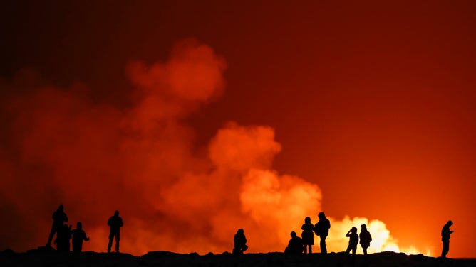 GRINDAVIK, ICELAND - DECEMBER 19: People view the volcano on the Reykjanes peninsula in south west Iceland which has erupted after weeks of intense earthquake activity/ on December 19, 2023 in Grindavik, Iceland. After weeks of seismic activity around Grindavik that led to the evacuation of some 4,000 residents, a volcano has erupted on the Reykjanes peninsula, with lava bursting from a crack about 3.5km long. (Photo by Jeff J Mitchell/Getty Images)