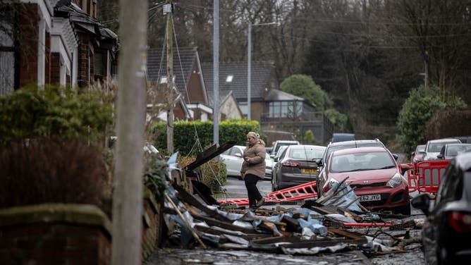 Resident Rebecca Saycell waits outside her house after the roof was ripped off in the aftermath of a tornado on December 28, 2023 in Stalybridge, England. 