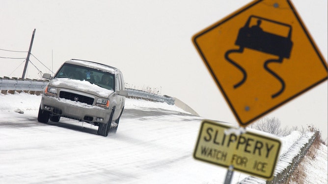 A car navigates down an icy road, December 9, 2005 in Toledo, Ohio. Seven inches of snow fell overnight marking the first significant snow fall of the year.