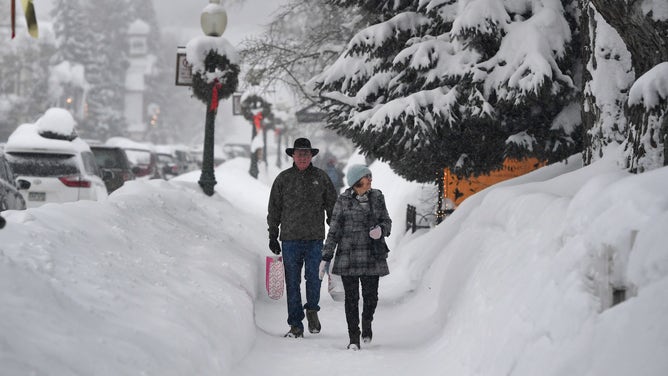 CRESTED BUTTE, COLORADO - JANUARY 11: Al and Linda Landgraff, from St. Peter, Minnesota, walk down the snowy main street as they shop on January 11, 2017 in Crested Butte, Colorado. Downtown Crested Butte has been inundated with more than 100 inches of snow in the past days. More snow is expected in the upcoming days. (Photo by Helen H. Richardson/The Denver Post via Getty Images)
