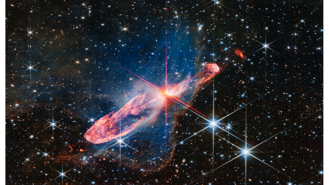 At the center is a thin horizontal orange cloud known as Herbig-Haro 46/47 that is uneven with rounded ends, and tilted from bottom left to top right. 