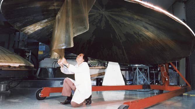 Archival image showing an engineer on the Voyager team working on the construction of the dish-shaped Voyager antenna. July 9, 1976.