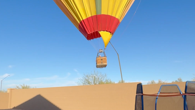 The balloon remains caught on the streetlamp.