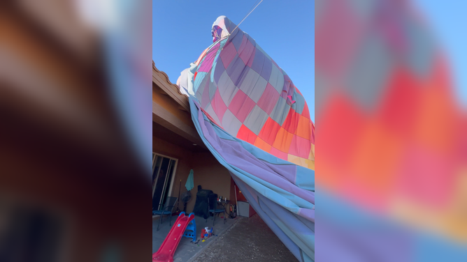 The deflated balloon blankets part of a home and yard.