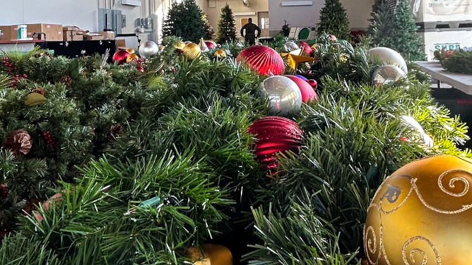 Decorations awaiting to be placed cover a table inside Hangar 123, the new location for this year’s NORAD Tracks Santa program at Peterson Space Force Base, Colo., Dec. 20, 2024. Hangar 123 will provide more space and a more operational feel for the more than 1,000 volunteers who will enter the NTS Operations Center on Dec. 24 to answer phone calls from people around the world asking for Santa’s location. (Department of Defense photo by Michelle Martin)