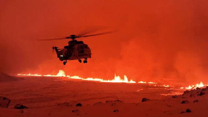 A helicopter is seen flying near a volcanic eruption in Iceland on Monday, Dec. 19, 2023.
