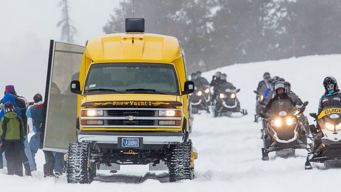 Snowmobiles and a snowcoach at the Midway Geyser Basin. NPS/Neal Herbert