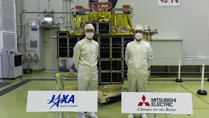 A photo of SLIM inside the Spacecraft and Fairing Assembly Building at Tanegashima Space Center in Japan ahead of launch. Left : Sakai Shinichiro, JAXA SLIM Project Manager. Right : Ogura Yuichi, Mitsubishi Electric Corporation SLIM Project Manager. 