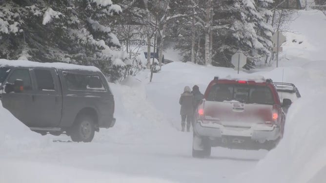 A photo showing vehicles trying to drive on snow-covered roads in Anchorage, Alaska.