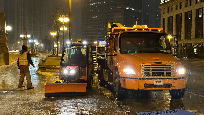 Crews are seen treating roads and sidewalks in Chicago on Tuesday, Jan. 23, 2024.