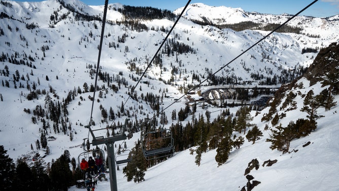 Visitors ride a ski lift at Palisades Tahoe ski resort in Olympic Valley